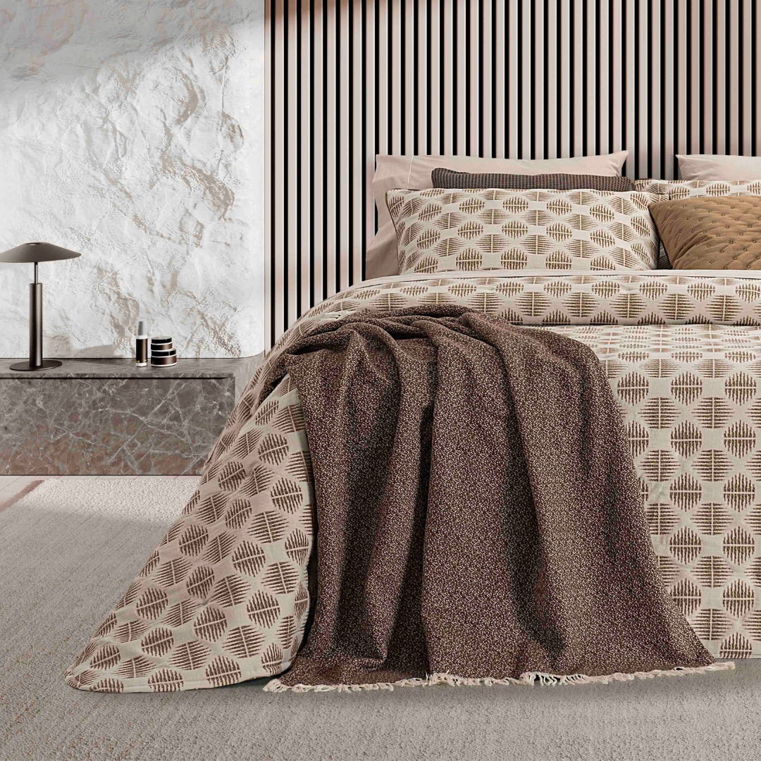 Pormenor do padrão geométrico jacquard do Edredão Conforter Oslo Camel, com almofadas e manta decorativa