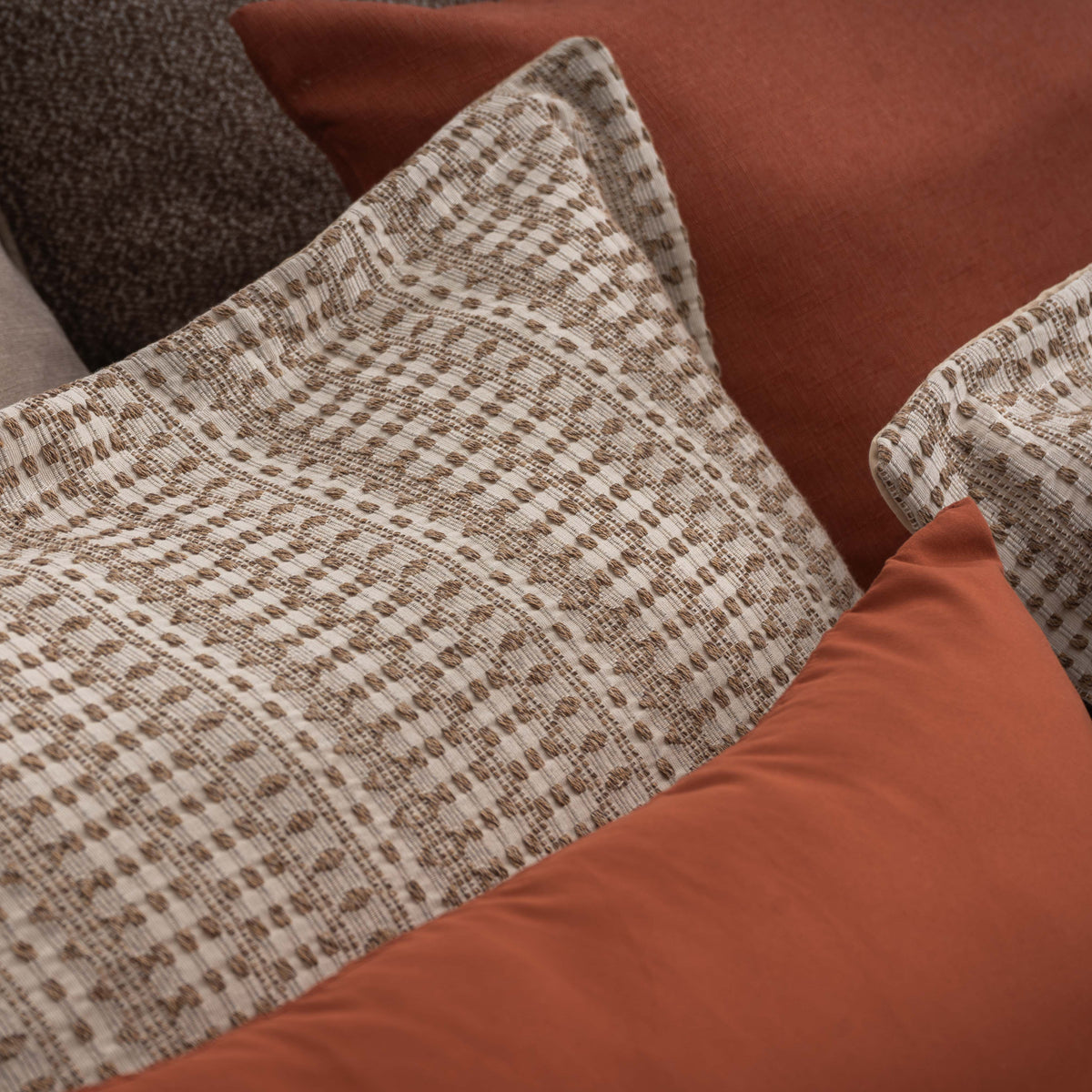 Pormenor do tecido jacquard e da almofada do Edredão Conforter Calen Camel