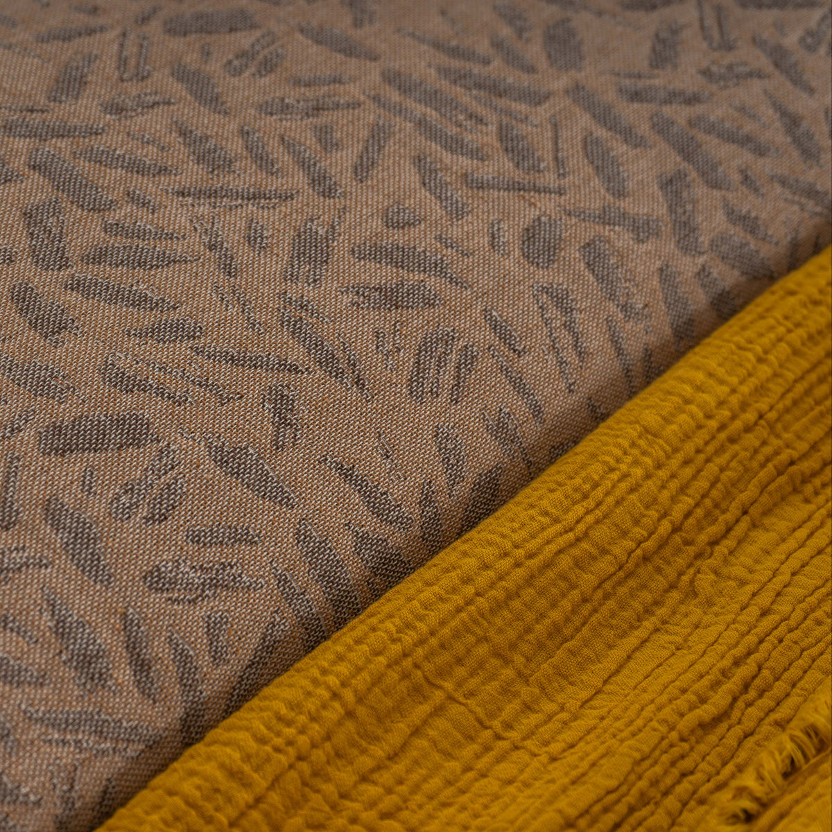 Pormenor do padrão jacquard e do acabamento do Edredão Conforter Doren Camel e da manta Gaze amarelo