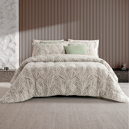Edredão Conforter Jacquard Marco Verde numa cama de casal, com padrão de folhas e almofadas coordenadas
