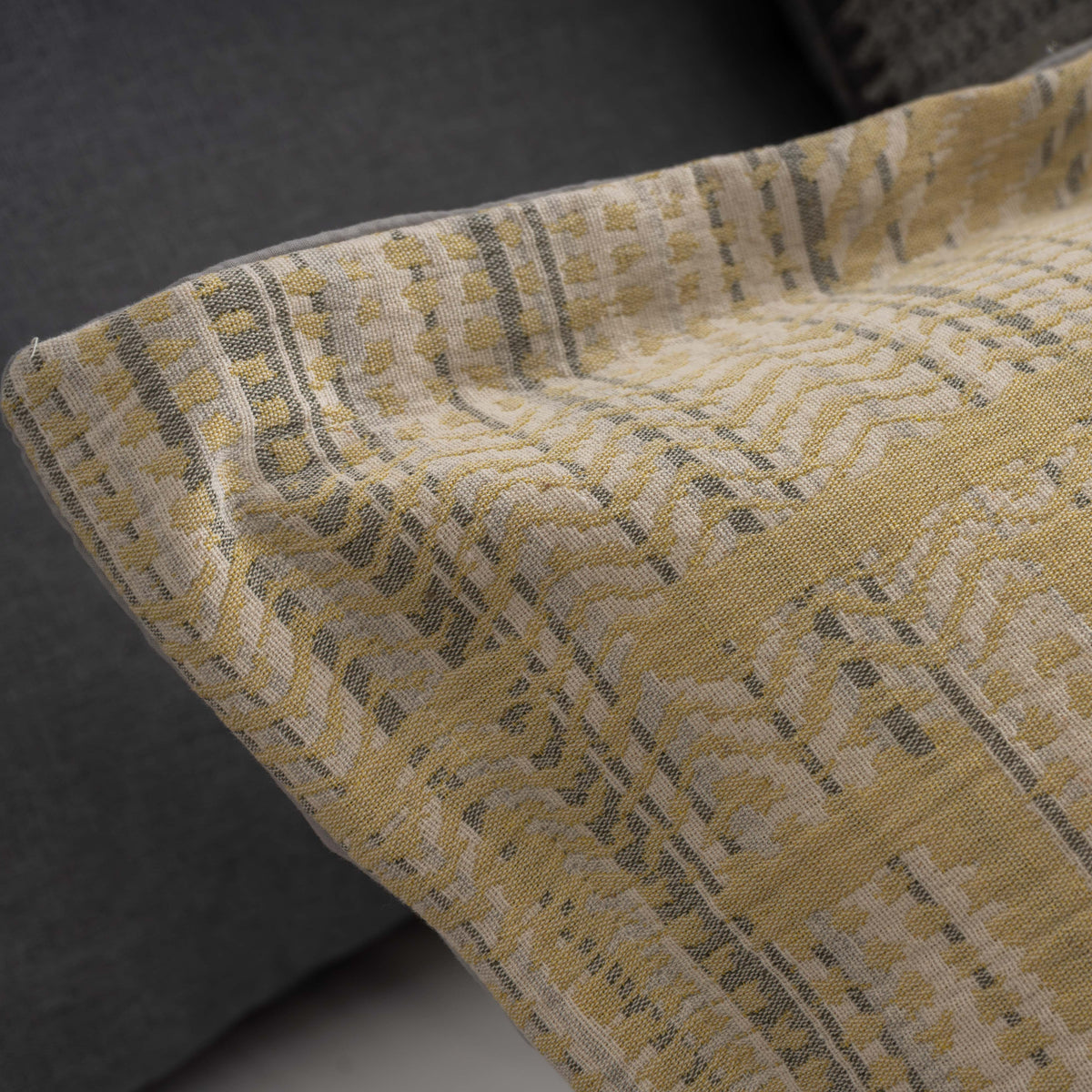 Pormenor do tecido jacquard e do acabamento da orla do Edredão Conforter Vika Limão